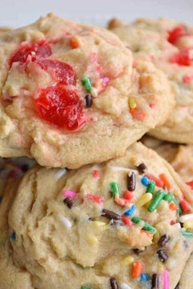 Stack of banana split cookies with maraschino cherries.