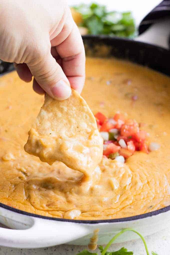 A chip dipping into homemade queso. 