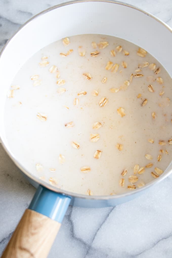Pot filled with oats and almond milk to make pumpkin pie oatmeal.