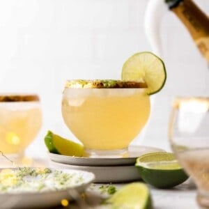 Glass of champagne margaritas with flowing champagne in the background.