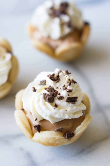 Mini French Silk Pies. Easy to make than you probably think and decadently DELICIOUS! Silky, creamy, chocolate bliss topped with homemade whipped cream. All in bite size mini pies!
