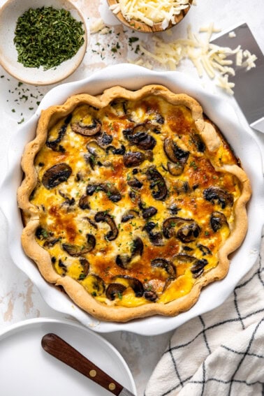 Mushroom quiche in a white ceramic pie dish.