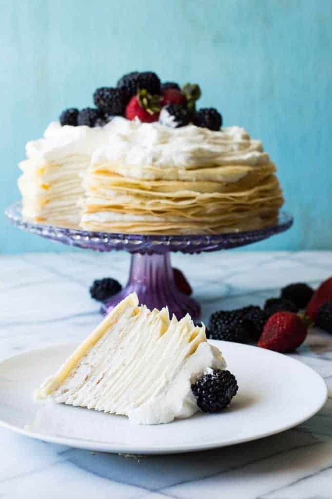 A whipped lemon mascarpone cream filling is layered with lightly sweetened crepes for a perfect dessert or brunch recipe!! Topped with lemon curd whipped cream and fresh berries! 
