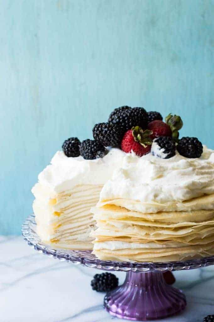 A whipped lemon mascarpone cream filling is layered with lightly sweetened crepes for a perfect dessert or brunch recipe!! Topped with lemon curd whipped cream and fresh berries! 