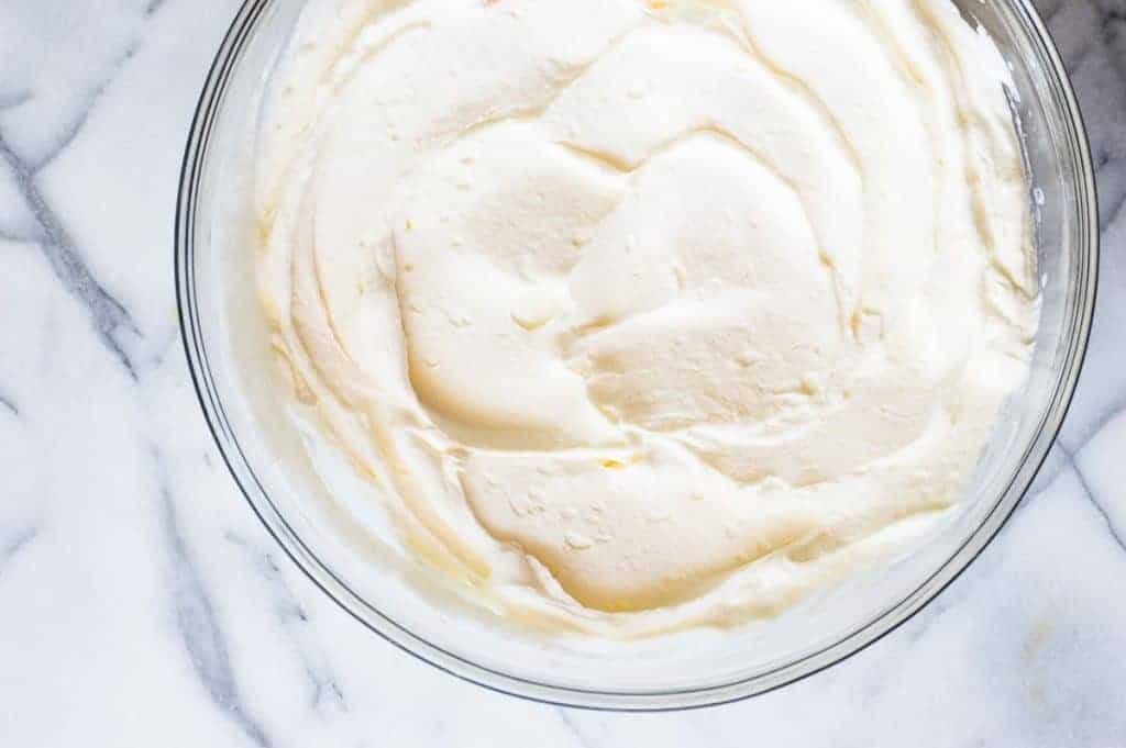 A whipped lemon mascarpone cream filling is layered with lightly sweetened crepes for a perfect dessert or brunch recipe!! Topped with lemon curd whipped cream and fresh berries! 