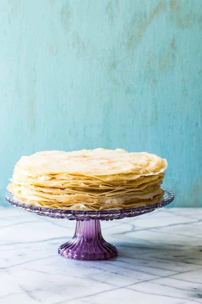 A whipped lemon mascarpone cream filling is layered with lightly sweetened crepes for a perfect dessert or brunch recipe!! Topped with lemon curd whipped cream and fresh berries! 