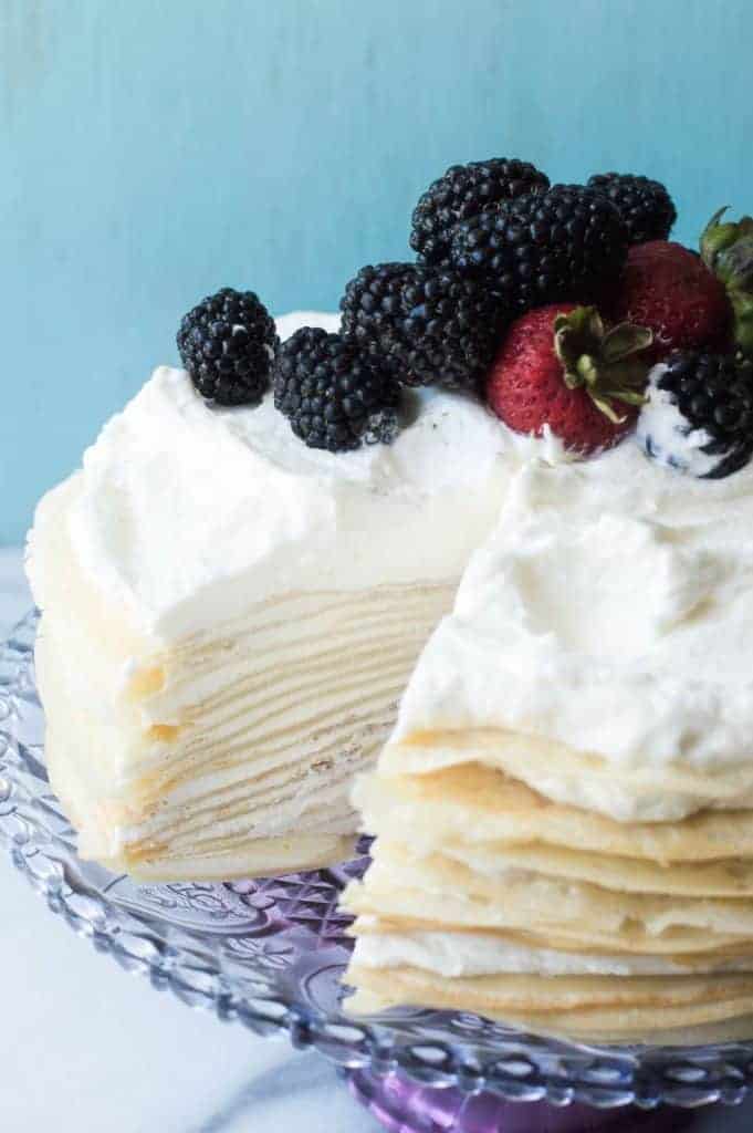 A whipped lemon mascarpone cream filling is layered with lightly sweetened crepes for a perfect dessert or brunch recipe!! Topped with lemon curd whipped cream and fresh berries! 