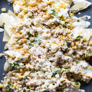 Mexican Street Corn Nachos! Chips loaded up with all the flavors of a classic mexican street corn and smothered with a creamy, spicy queso blanco.