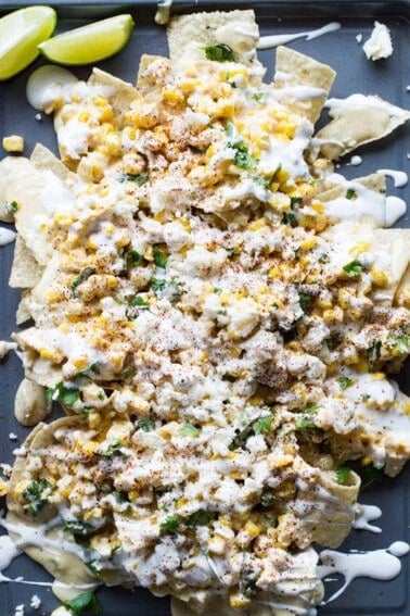 Mexican Street Corn Nachos! Chips loaded up with all the flavors of a classic mexican street corn and smothered with a creamy, spicy queso blanco.