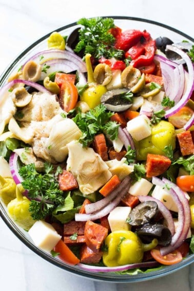 Antipasto Salad! The perfect side dish to go along with your Italian meals, loaded with artichoke hearts, roasted red peppers, olives, pepperoni, and fresh mozzarella! Not to mention drizzled with an easy to make vinaigrette made with pantry items!