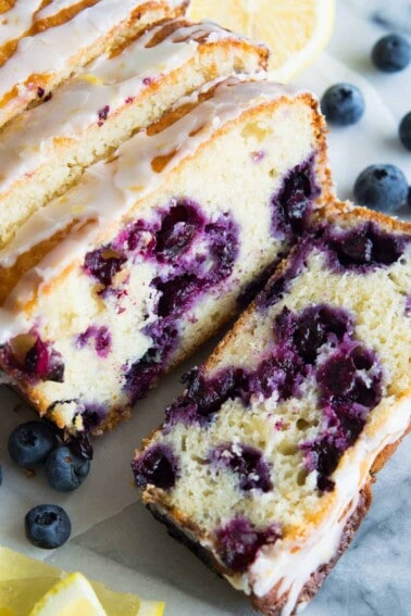 Blueberry Lemon Pound Cake! This pound cake is made lighter by using greek yogurt, and is loaded up with lemon flavor thanks to zest and fresh lemon juice! Juicy blueberries are baked right in. All drizzled with a luscious lemon glaze.