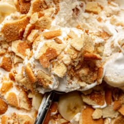 Banana ice cream being scooped with a wooden handled spoon.