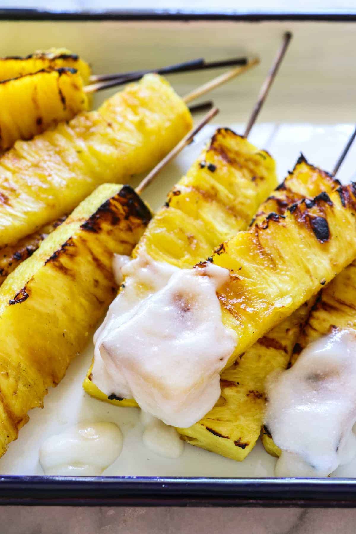 grilled pineapple dipped in coconut rum sauce.