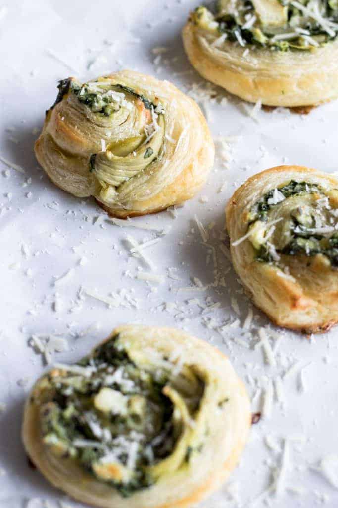 Puff Pastry Spinach and Artichoke Pinwheels. This easy to put together appetizer is perfect for any party or just as a snack. Loaded with fresh spinach, artichoke, and lots of cheese! 
