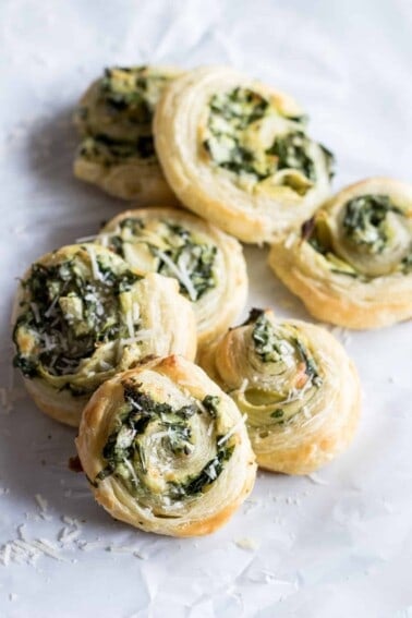 Puff Pastry Spinach and Artichoke Pinwheels. This easy to put together appetizer is perfect for any party or just as a snack. Loaded with fresh spinach, artichoke, and lots of cheese! 