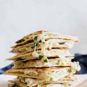 Stack of cheesy spinach and artichoke chicken quesadillas.