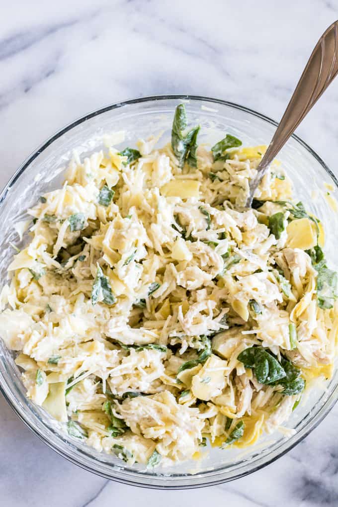Bowl full of spinach and artichoke chicken mixture for quesadillas.