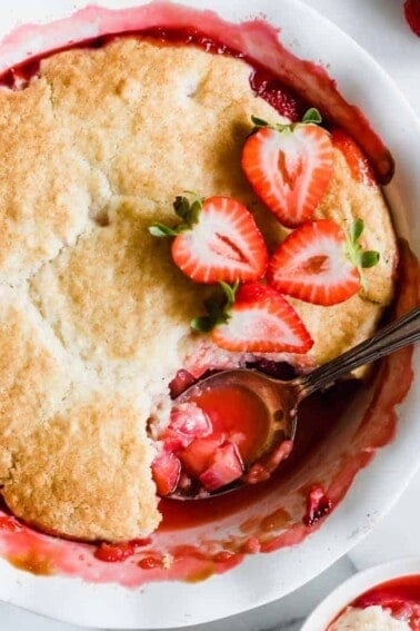 Spoon scooping out strawberry cobbler.