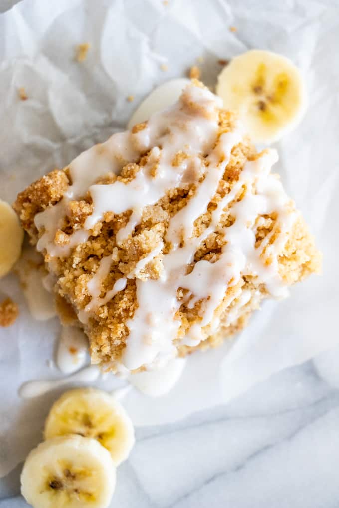 Overhead view of banana bread crumb cake showing the sweet brown sugar crumb on top and a drizzle of icing.