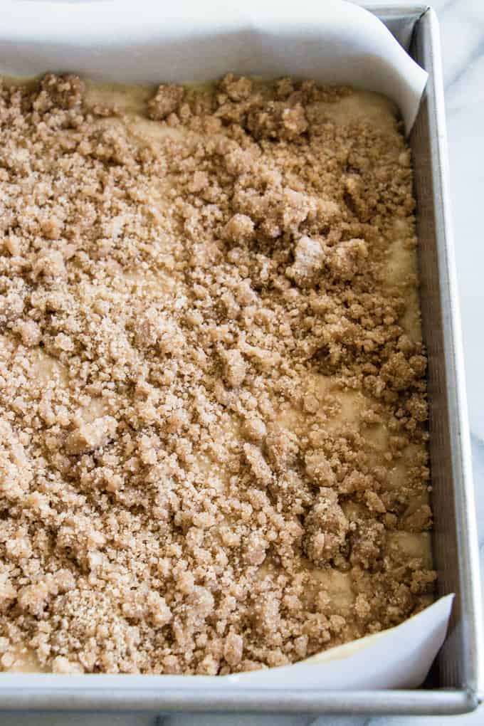 Banana bread crumb cake in a square baking pan topped with brown sugar crumb.