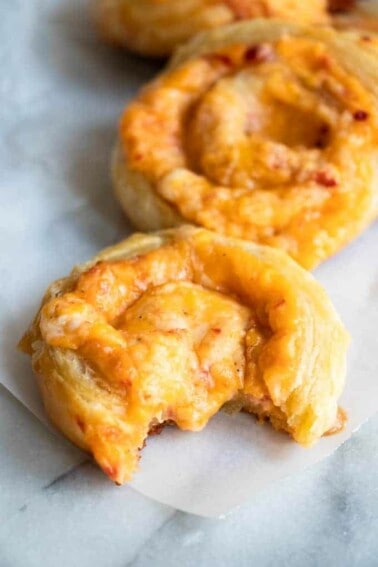 Pimento Cheese Pinwheel, with a bite missing and melty cheese oozing in the center.