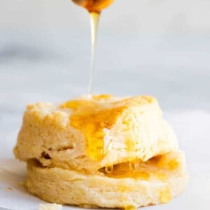 A biscuit being drizzled with honey.