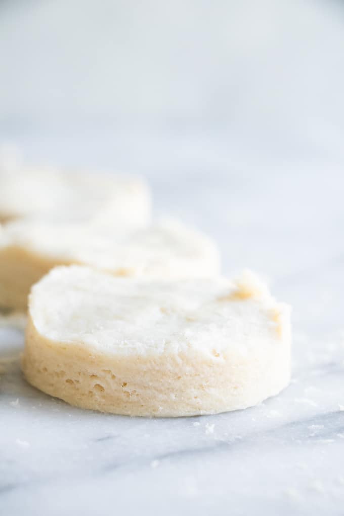 Close up image of a cut out biscuit showing the layers in the dough.
