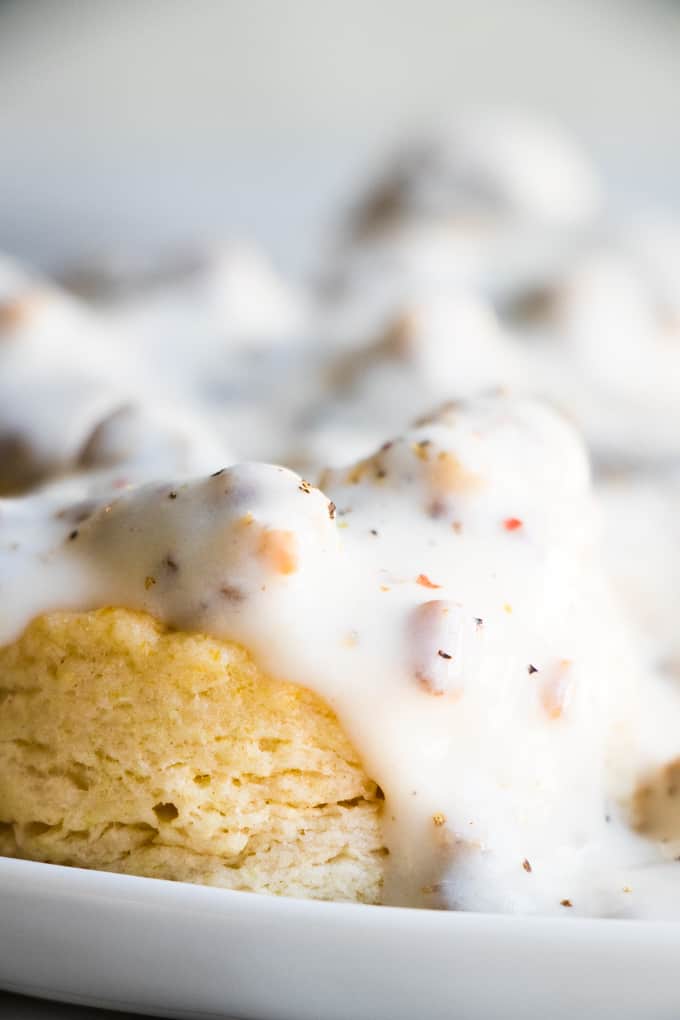 Sausage gravy dripping over the side of a biscuit.