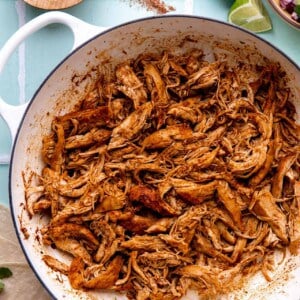 Skillet filled with shredded Mexican style chicken.