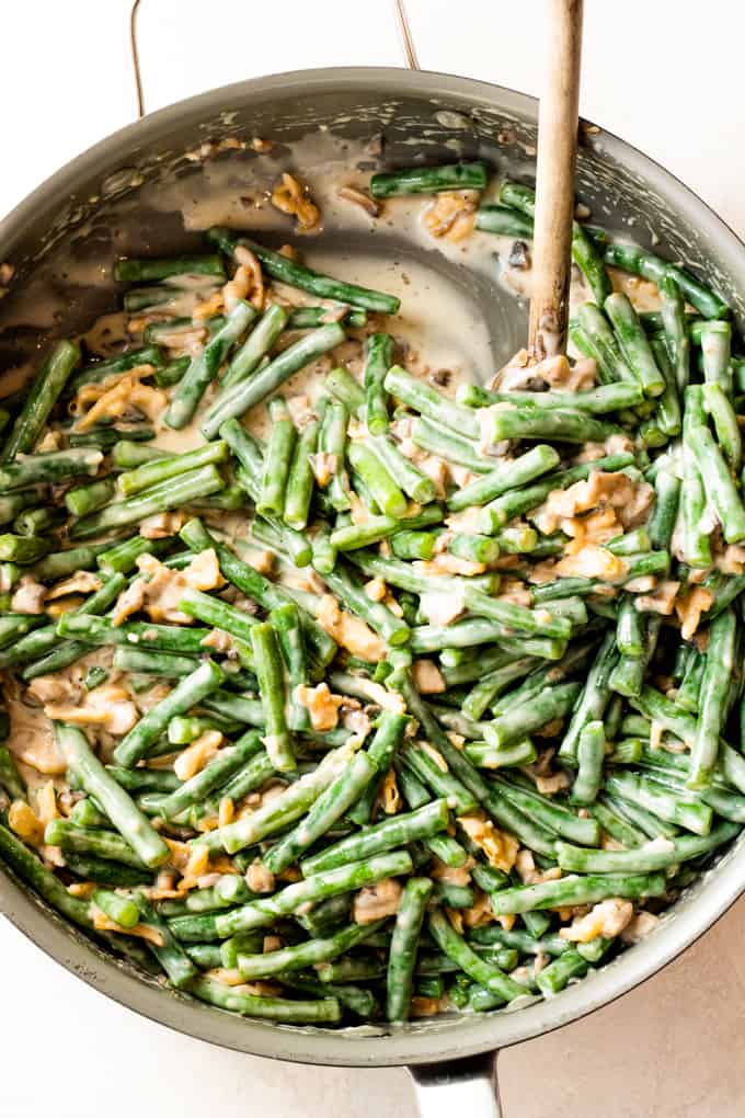 Large skillet filled with creamy green bean casserole ready to bake.