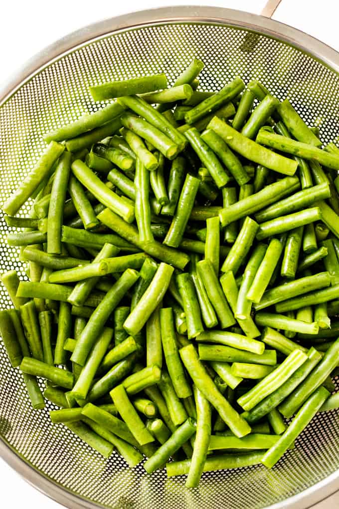 Fresh green beans in a strainer.