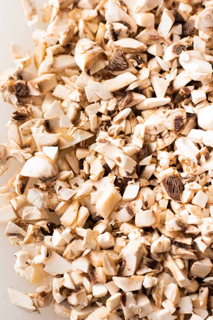 Chopped up mushrooms on a cutting board.
