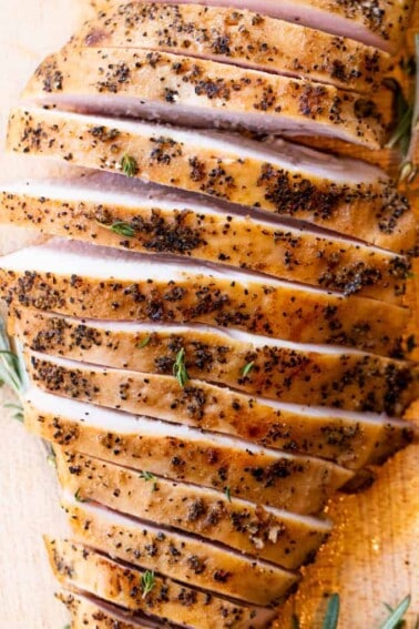 Sliced smoked turkey breast on a wood cutting board.