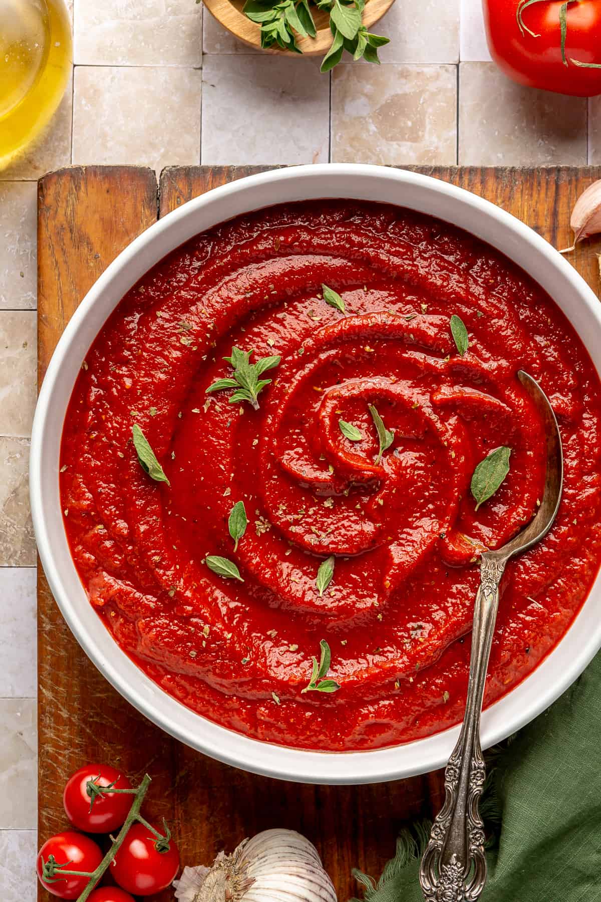 Bowl filled with homemade pizza sauce topped with fresh herbs.
