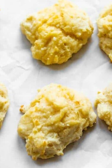 Overhead of biscuits on a piece of parchment paper.