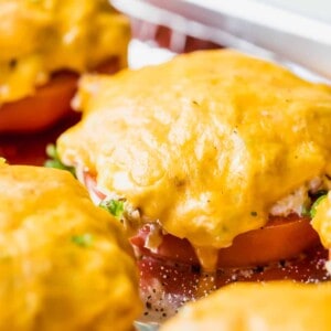 Slice of tomato topped with tuna salad and covered with melted cheese.