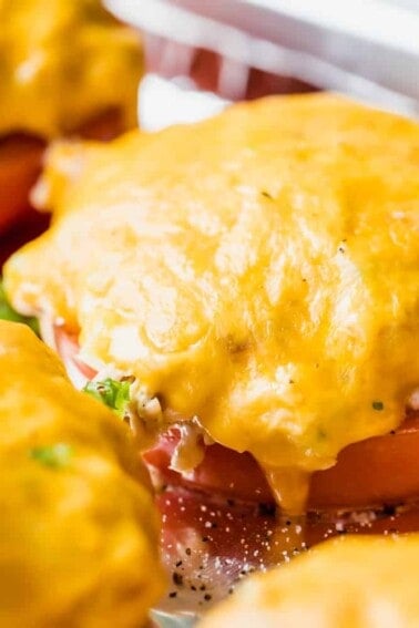 Slice of tomato topped with tuna salad and covered with melted cheese.