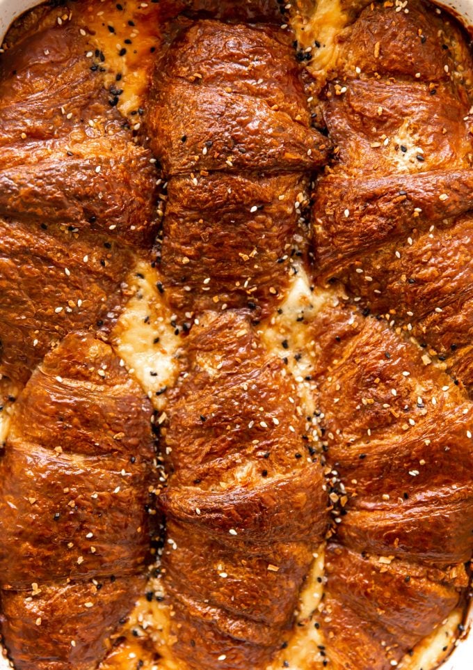 Baked Breakfast Casserole with ham and cheese croissants, topped with everything bagel seasoning.