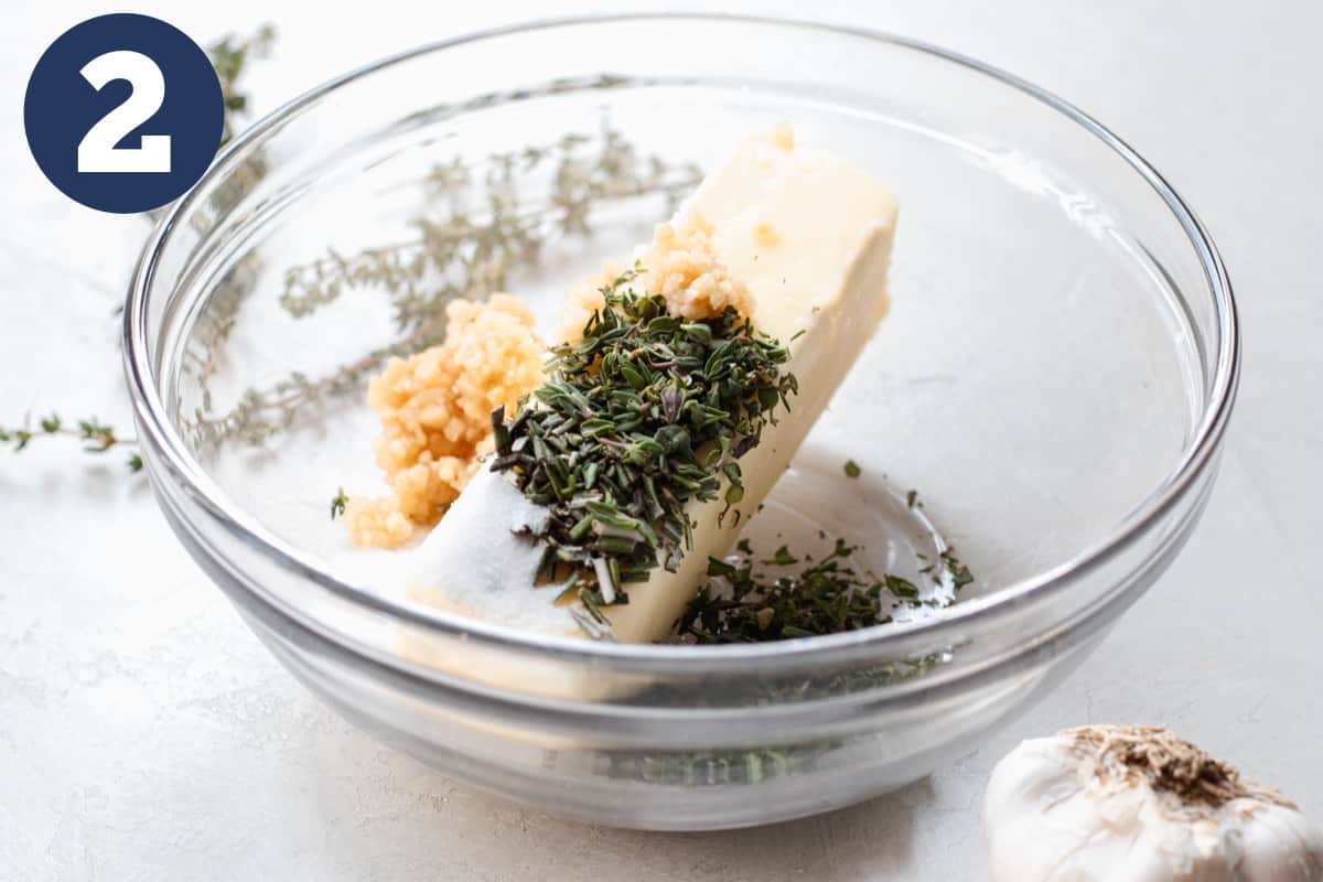 Bowl with butter, garlic, and fresh herbs for seasoning a prime rib.
