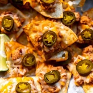 Texas Nachos made with refried beans, cheese and jalapeno on a tray to be served.