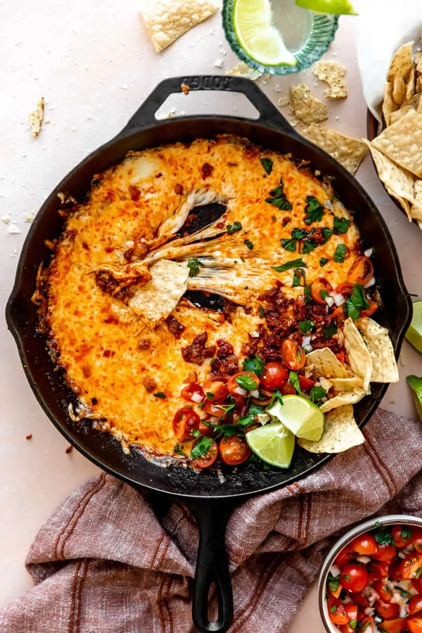 stretchy melted cheese in a skillet with chorizo and pico de Gallo. 