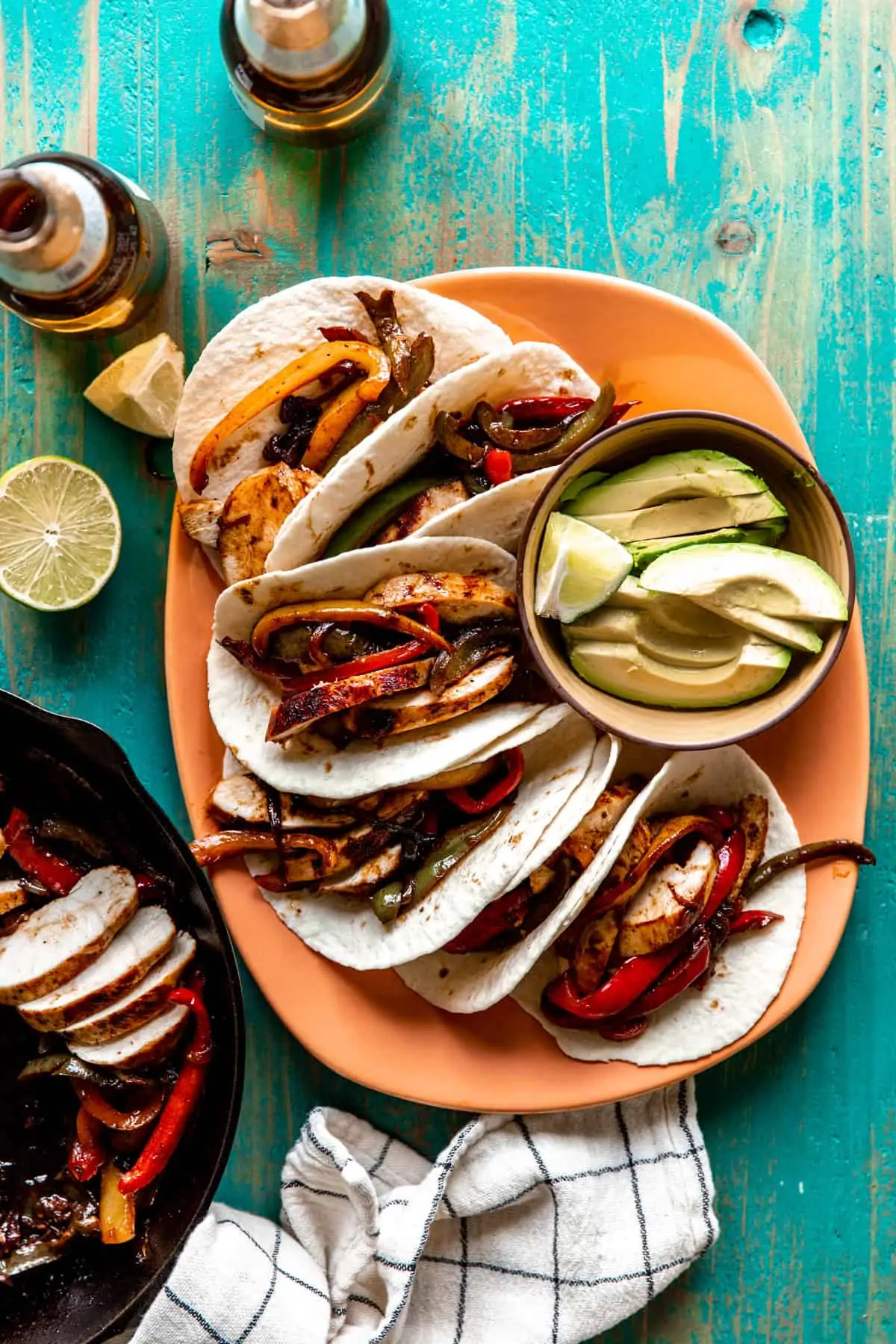 Plate filled with chicken fajitas served in flour tortillas. 