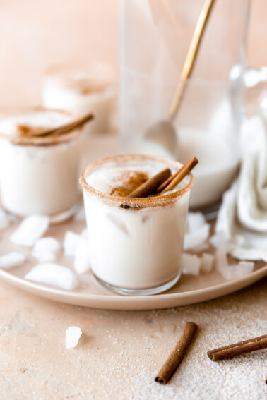 Glass rimmed with cinnamon and filled with cold and creamy homemade horchata, served with cinnamon sticks.
