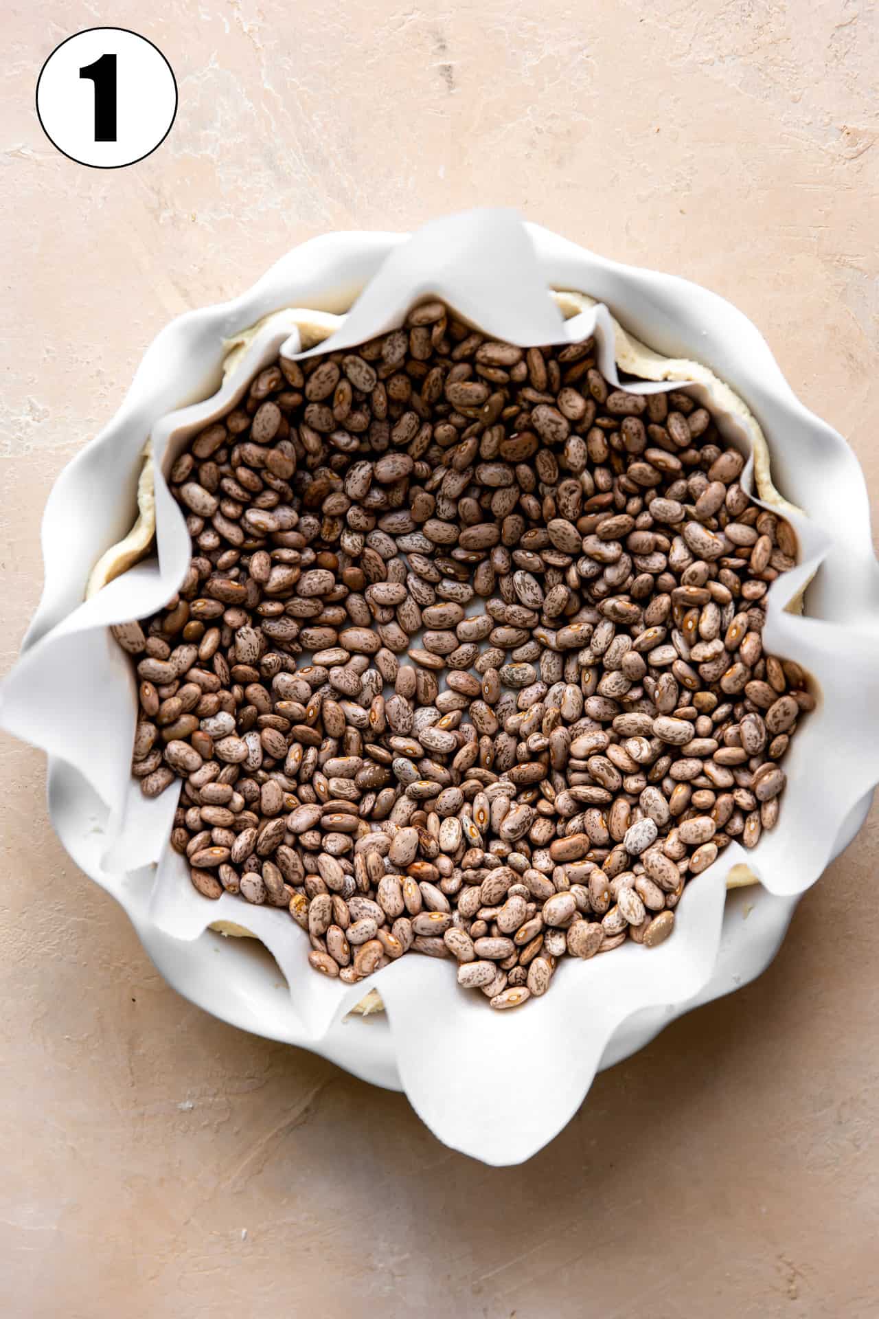 Image showing how to blind bake a pie crust to make a quiche.