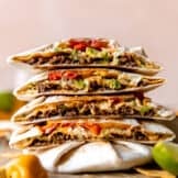 Stack of homemade Crunchwraps cut in half to show all the fillings inside.