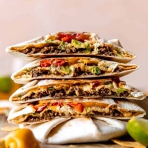Stack of homemade Crunchwraps cut in half to show all the fillings inside.