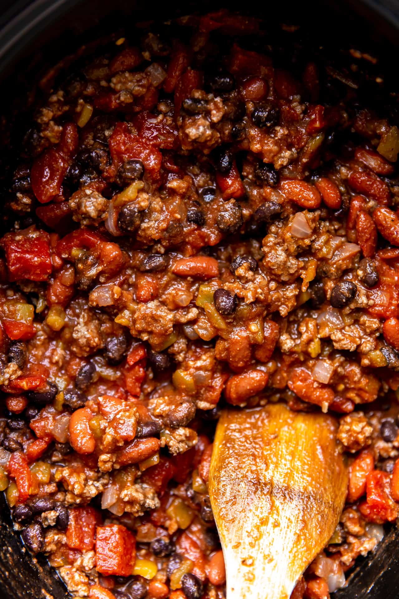 Chunky homemade ground beef chili being cooked in a large pot.
