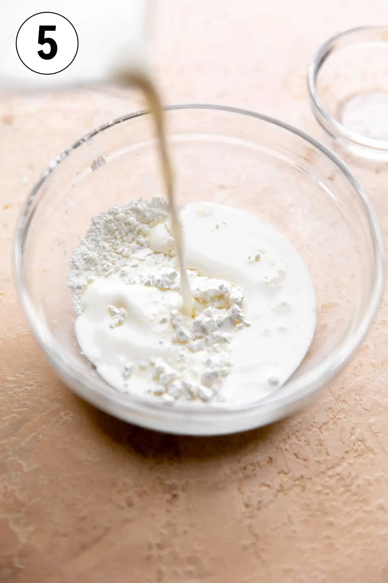 Milk being added to corn starch to make a slurry for thickening the soup.