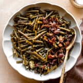 Dish of southern green beans topped with crispy bacon.