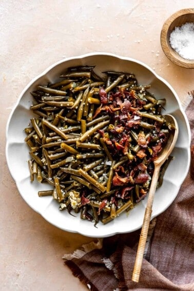 Dish of southern green beans topped with crispy bacon.